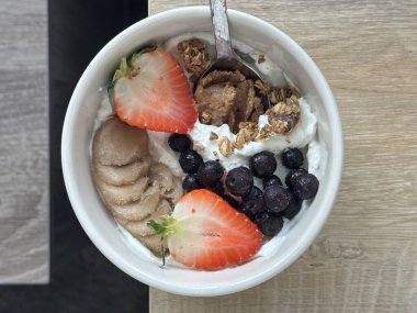 Creamy yogurt bowl topped with fresh fruits and crunchy toppings, offering a smooth texture and refreshing taste. Light, wholesome, and visually appealing, perfect for breakfast or healthy snack.