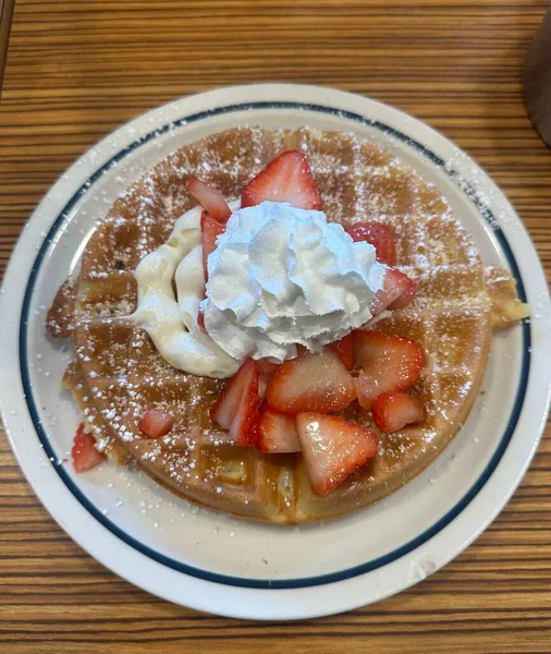 Üstünde bol kremalı vanilyalı dondurma ve çikolata sosu serpiştirilmiş çıtır altın waffle. Klasik, hoşgörülü bir tatlı..