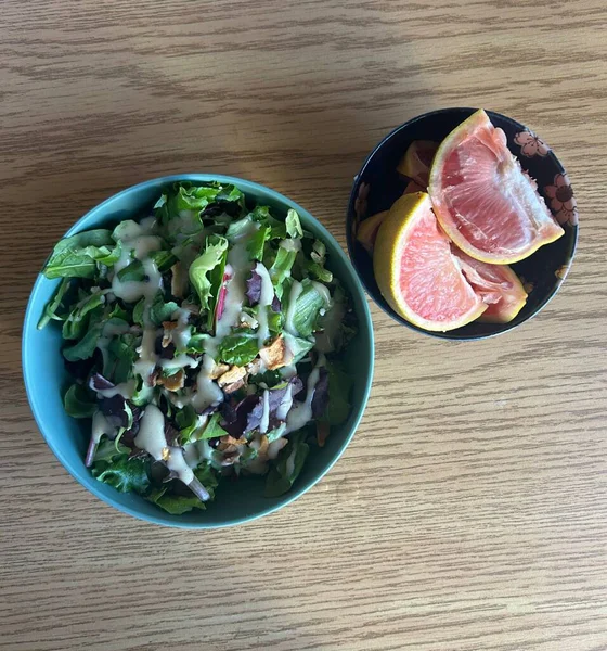 Taze salata taze yapraklı sebzeler, dilimlenmiş sebzeler ve rengarenk malzemelerin karışımı sağlıklı, canlı ve ferahlatıcı bir tat yaratmak için bir araya getirilmiş.