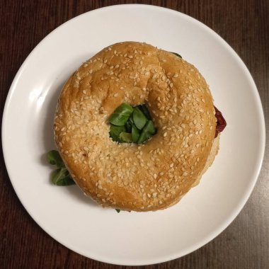 Lezzetli malzemelerle dolu gevrek bagel sandviçi ve çıtır patates cipsi. Zengin doku, dengeli tatlar ve klasik konfor cazibesi sunan doyurucu ve tatmin edici bir kombinasyon..