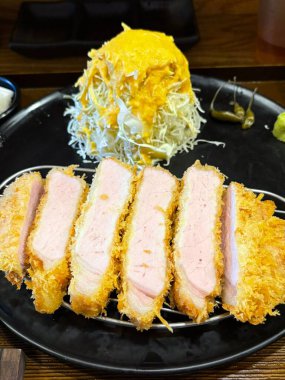 Çıtır tonkatsu, Japon usulü kızarmış domuz pirzolası dilimlenmiş lahana ve tuzlu sosla servis edilir. Lezzetli bir kıtır kıtır doku ve sulu et dengesi.