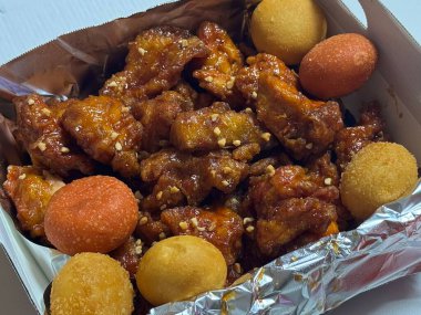 Kızarmış Kore tavuğu, tatlı ve baharatlı sosla mükemmel bir şekilde jölelenmiş. Yemek fotoğrafçılığı ve menüler için idealdir. Bu sevilen yemeğin dayanılmaz çıtırtısını ve lezzetini sergiler..