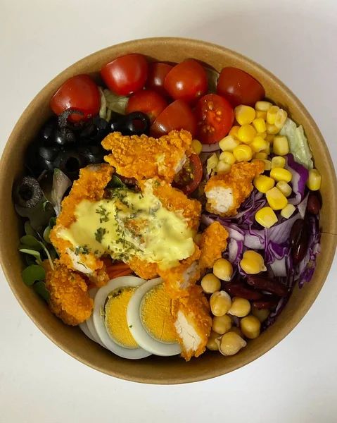 Taze salata taze yapraklı sebzeler, dilimlenmiş sebzeler ve rengarenk malzemelerin karışımı sağlıklı, canlı ve ferahlatıcı bir tat yaratmak için bir araya getirilmiş.