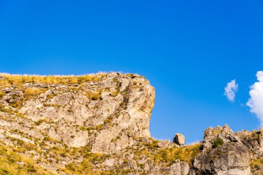 Güneşli Kayalık Kayalıklar, Derin Mavi Gök Altında Kuru Çimen Altında Parlak Bir Yaz Günü Dağlık bir arazide