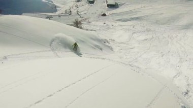 Bir snowboardcunun dik yamaçta küçük bir çığı tetiklediği, kar yığınında dengesizlik ve taşra tehlikesini gösteren yavaş çekim görüntüleri..