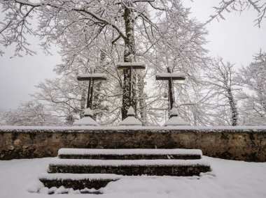 Conceptual image of faith. A calvary monument with three crosses stands in the snow, symbolizing sacrifice, hope, and contemplation on a cold winter day.
