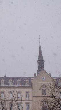 Fransa 'nın Saint-Laurent-du-Pont kentinde aktif kar yağışı sırasında tarihi bir binanın bulunduğu atmosferik kış arkaplanı. Tatil pazarlaması için mükemmel..