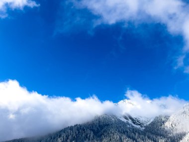 Arzu, meydan okuma ve başarı kavramı, açık bir gökyüzüne doğru yükselen dağ zirvesi ile sembolize ediliyor. Yüksek dağlık ortamın saflığı ve berraklığı.