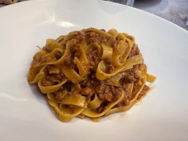 Tagliatelle al ragu ile tabakları kapatın - uzun, et soslu yumurta makarna ya da sucuk soslu ve parmesan peynirli, biberiyeli