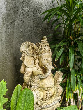 Güzel bir dağ bahçesindeki Ganesha heykeli. Taştan yapılmış Ganesha heykeli, arka planda güzel bir dağ bahçesi var.
