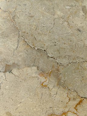 Yumuşak, yıpranmış taş bir yüzeye yakın çekim, ince tahıl, doğal benekler, ve bej ve açık kahverengi yumuşak tonlarda varyasyonlar, sakin, dünyevi ve minimalist estetik çağrıştıran.