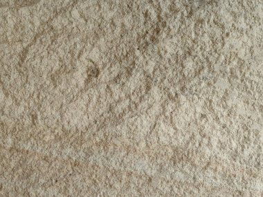 Yumuşak, yıpranmış taş bir yüzeye yakın çekim, ince tahıl, doğal benekler, ve bej ve açık kahverengi yumuşak tonlarda varyasyonlar, sakin, dünyevi ve minimalist estetik çağrıştıran.