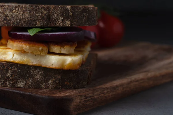 Lezzetli bir vejetaryen sandviçi ızgara halloumi peyniri, taze ıspanak ve tuzlu ekşi ekmeğin üzerine kırmızı soğan.