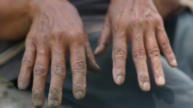 Çok çalışma ve yaşlılık belirtileri gösteren yaşlı bir insanın yıpranmış elleri. Çalışkan bir çiftçinin ya da işçinin kirli ellerine yakın durun.