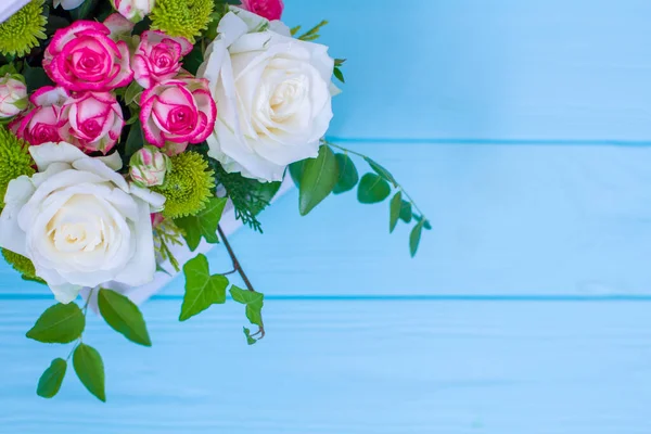 Tahta kutuda beyaz ve pembe güller ve turkuaz ahşap tahta üzerinde kasımpatılar. Evin dekorasyonu. Çiçek kutuları. Düğün süslemesi