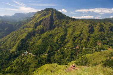 Ella, Sri Lanka, 22 Aralık 2015: Bir adam ve bir kadın, bir dağ virajlı yolun zemininde yatıyor.