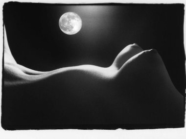 Güzel çıplak kadın göğüsleri arka planda ve ayda. Dikkat! Resim, analog fotoğrafçılığın metanet ve diğer eserlerini içerir.!