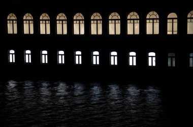 Geceleri, evin pencereleri suya yansıtılır. Kaliningrad.