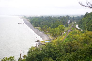 Bulutlu bir günde deniz ve demiryolu manzarası. Georgia.