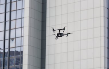 Profesyonel casus uçak uçan şehir sokaklarını. Şehir özgeçmişlerine robot. Casus uçağı, şehir manzarası. Kent üzerinde uçan helikopter.
