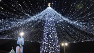 Şenlikli yılbaşı ağacı. Geceleri ışıklar sokaklarda.