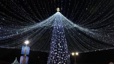 Şenlikli yılbaşı ağacı. Geceleri ışıklar sokaklarda.