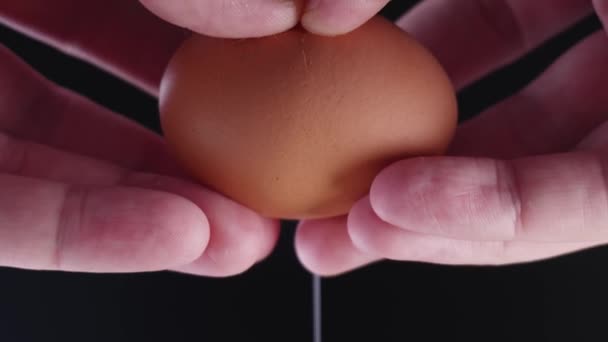 Närbild av ett ägg i handen som bryts sönder för att steka slow mo — Stockvideo