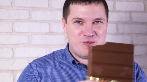 Man eating milk chocolate close-up — Stock Video