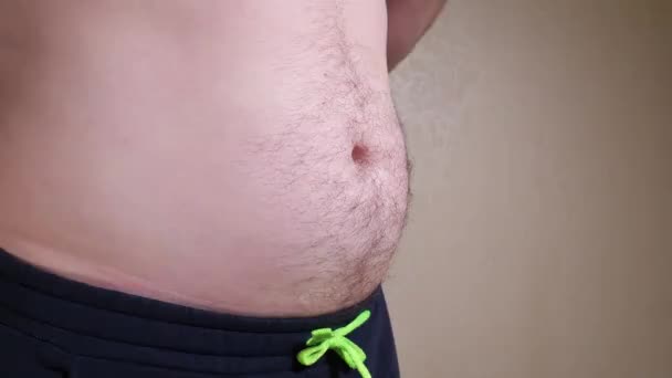 Barriga masculina fechar-se lento mo. Homem mostrando barriga de cerveja — Vídeo de Stock