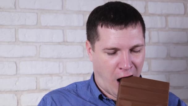 Человек ест молочный шоколад крупным планом — стоковое видео