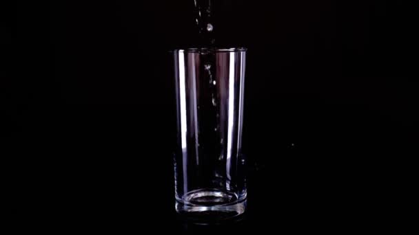Заполнение стакана водой темный ключ медленный мо — стоковое видео