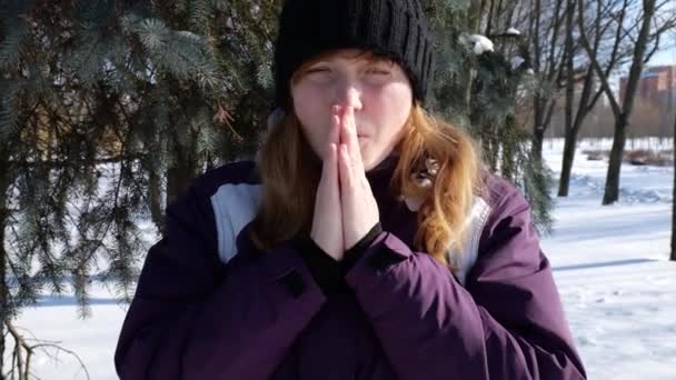 Девушка в холоде массирует свои замороженные руки — стоковое видео