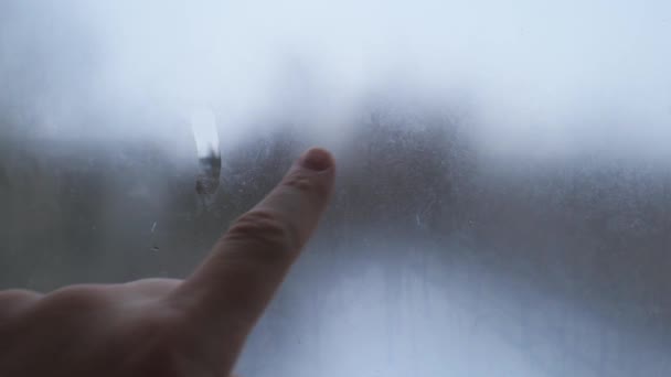 Hand schildert een droevig gezicht op het misvormde glas. Symbool van eenzaamheid en verdriet — Stockvideo