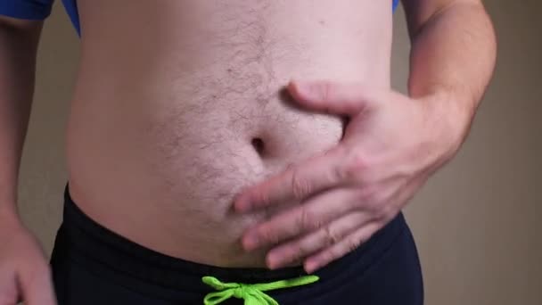 Vientre masculino primer plano lento mo. Hombre mostrando barriga de cerveza — Vídeos de Stock