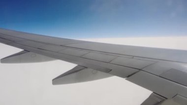 Bir uçak kanadı ve uçan bulutların görüntüsü