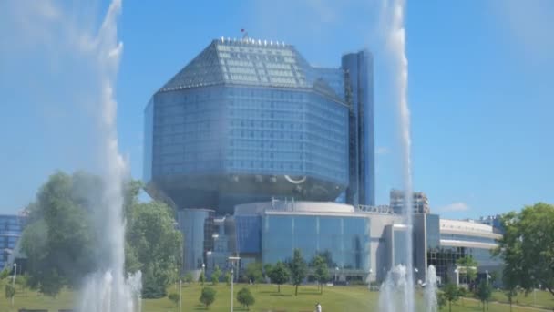 Minsk Belarus juni 2021. Nationale Bibliotheek tegen de achtergrond van de slow mo fonteinen — Stockvideo
