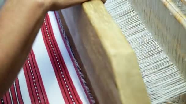 Ткань делает ткацкий станок крупным планом. мужчина на деревянном ткацком станке тормозит. — стоковое видео
