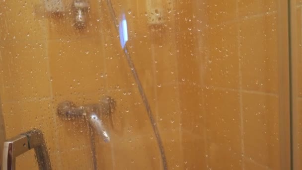 Cabine de douche. gouttelettes d'eau sur une porte de douche brouillée — Video