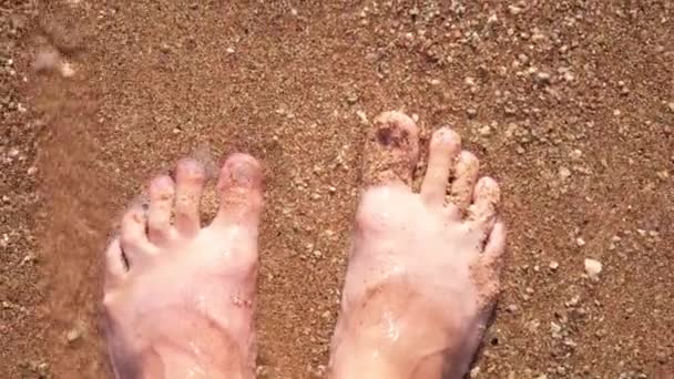 Piedi maschili sulla spiaggia in acque poco profonde nella sabbia primo piano lenta mo — Video Stock