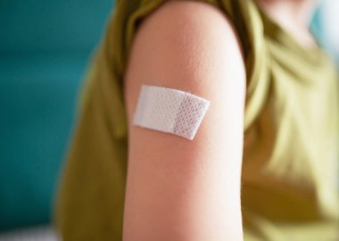 Aşı, sağlık ve bağışıklık konsepti, koruma, tıbbi bakım, önleme ve pediatrik sağlıktan sonra yapıştırıcı ile çocuk koluna yakın çekim. Yüksek kalite fotoğraf