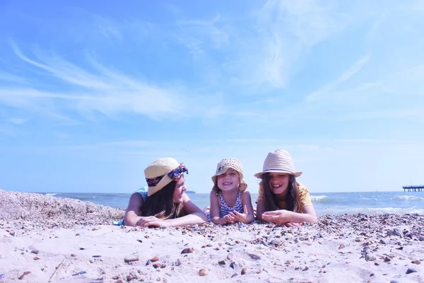 Tres chicas tumbadas en la playa — Foto de Stock