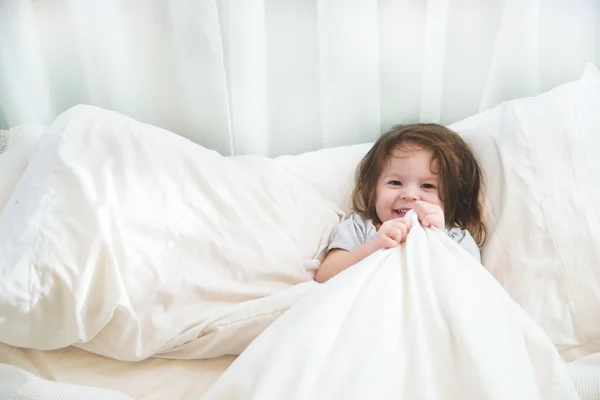 Girl in pajamas lying in bed — Stock Photo, Image