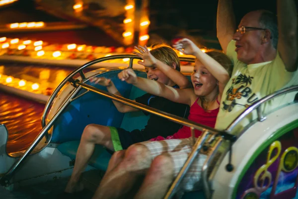 Family on amusement park ride — Stock Photo, Image