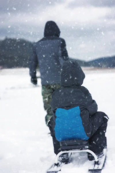 保加利亚 一个男人在雪橇上拖着一个孩子的后视镜 — 图库照片