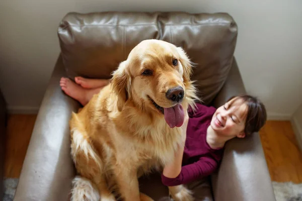 Счастливая Девушка Сидит Кресле Золотой Собакой Ретривером — стоковое фото