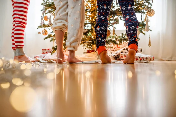 Primer Plano Las Piernas Tres Niños Mientras Decoran Árbol Navidad —  Fotos de Stock