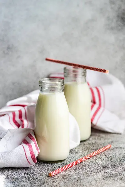 Två Flaskor Mjölk Och Dricka Sugrör Bordet Bredvid Kökshandduk — Stockfoto