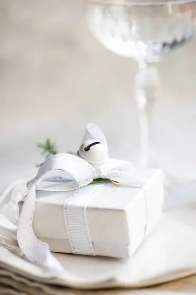 在桌子上的香槟酒沙发旁边的餐巾上夹着圣诞礼物 — 图库照片