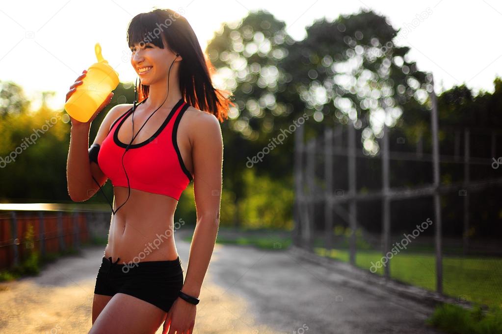 young fitness woman outdoor with protein shake
