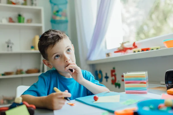 Estudiante pensante haciendo su tarea en casa . — Foto de Stock